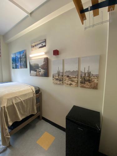 Corner view of room bed and fridge