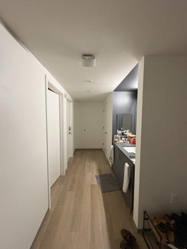 walkway (left are the bedrooms and on the right is a sink and the furthest door leads to the bathroom - bathtub/shower and toilet)