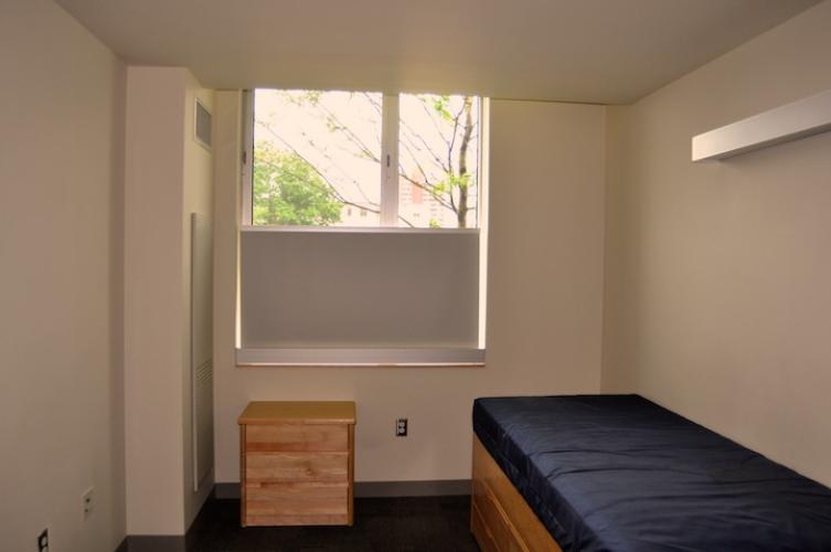 Bedroom with a bedside table with three drawers.