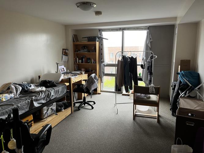 wall-to-wall carpet, floor-to-ceiling windows, facing southeast, twin-size bed with mattress, desk, chairs and rack