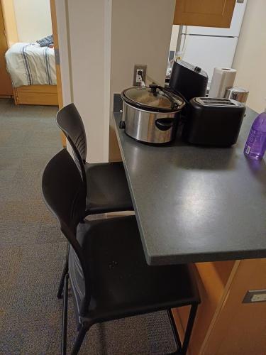 Two dinner table chairs next to the kitchen table/workspace