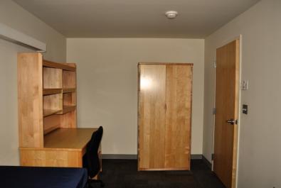 Bedroom showing desk with shelves above the desk for storage.