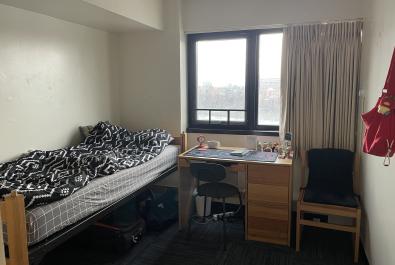 Bedroom layout. The bed is to the left upon entrance and the desk is straight ahead, before the window.